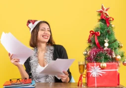 Mujer revisando documentos junto a regalos de Navidad, concepto de planificación financiera y préstamos para Navidad.