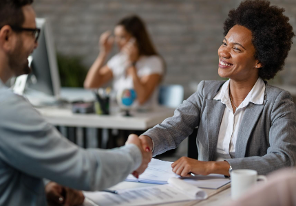 Persona firmando un préstamo con asesor financiero en oficina, acuerdo de crédito aprobado en Argentina.