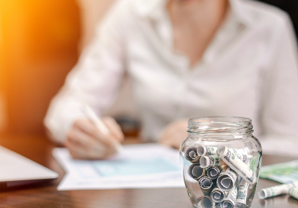 Mujer organizando sus finanzas personales mientras aprende cómo reducir los intereses de un préstamo y ahorrar dinero en Argentina.