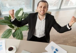 Homem comemorando aprovação de empréstimo após melhorar perfil financeiro e conseguir crédito no banco