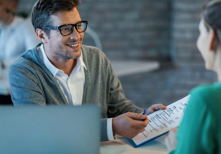 Cliente analisando contrato de empréstimo com atendente para verificar cobrança de seguro no empréstimo sem avisar