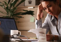 Mulher preocupada analisando contas e considerando empréstimo para limpar o nome e quitar dívidas atrasadas