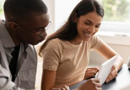 Casal analisando score de crédito no tablet após contratar empréstimo pessoal