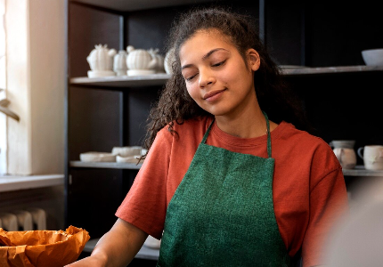 Mulher trabalhando de forma autônoma e usando celular, representando renda informal e busca por empréstimo