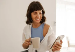 Pessoa aliviada usando celular após limpar o nome e regularizar situação financeira