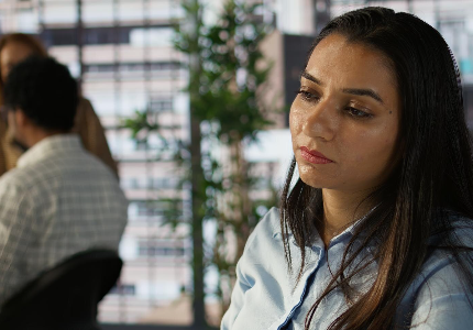 Mulher preocupada analisando sua situação financeira após variação no score de crédito