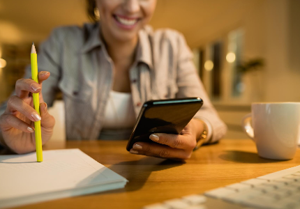 Pessoa tranquila organizando finanças no celular, representando hábitos financeiros saudáveis