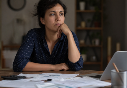 Pessoa pensativa preocupada com dívidas e dificuldades financeiras