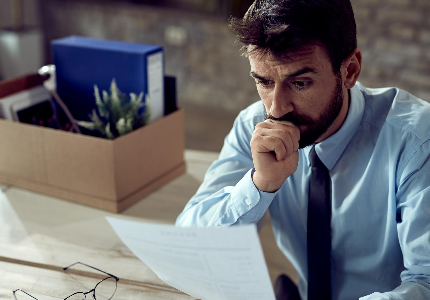 Hombre revisando documentos financieros con preocupación, analizando gastos y situación económica personal